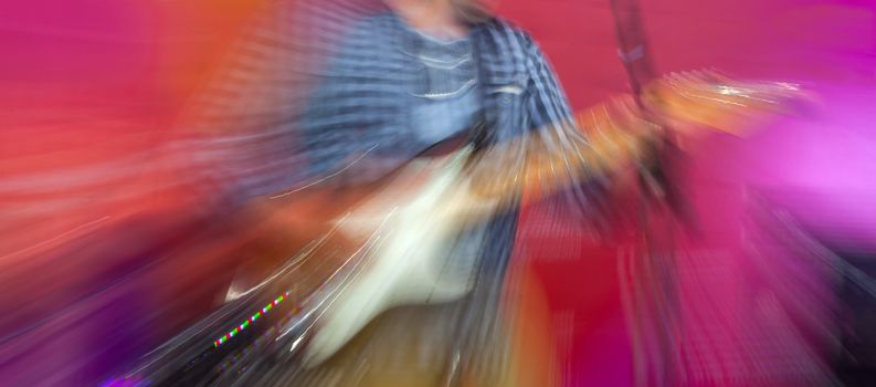 Guitarist on the stage. Motion blur on an electric guitar