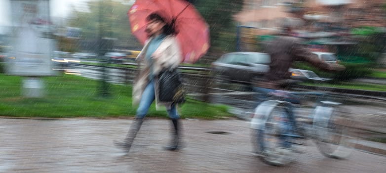 Rainy day in the city  in motion blur. People going about their business