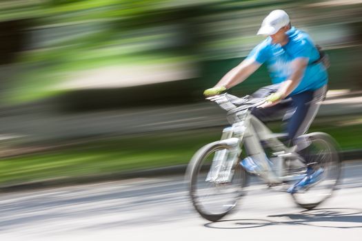 cyclist in traffic on the city roadway. Intentional motion blur