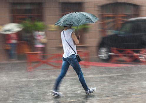 People walking down the street in rainy day. Intentional motion blur