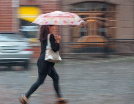 People walking down the street in rainy day. Intentional motion blur