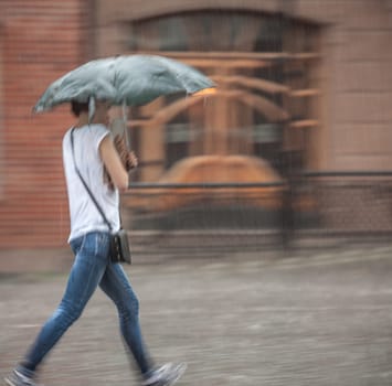 People walking down the street in rainy day. Intentional motion blur