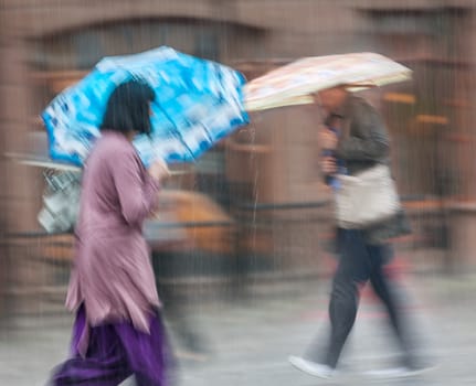 Group of people walking down the street in rainy day. Intentional motion blur