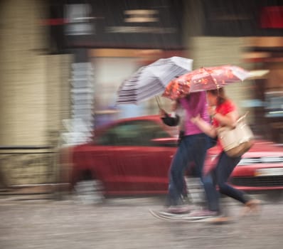 People walking down the street in rainy day. Intentional motion blur