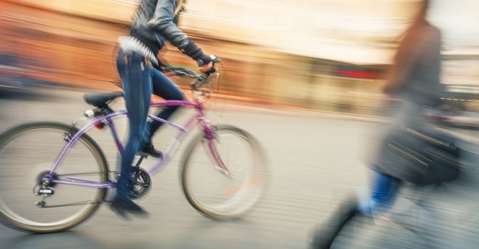Cyclists and pedestrians in the city. Young people going about their business. Intentional motion blur