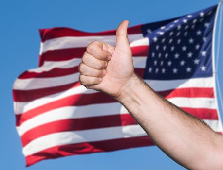 Patriotic concept. Tumb up sign against of United States of America flag