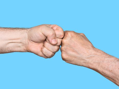 Two men bumping fists isolated on blue background