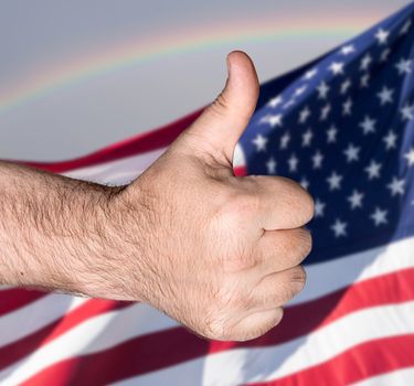Patriotic concept. Thumb  up sign against of United States of America flag