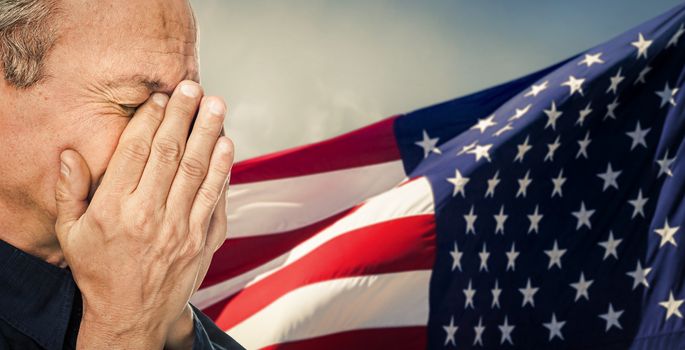 Veteran. Portrait of an elderly man with face closed by hand on USA flag background. Intentional color shift