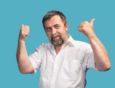 Successful man shows thumbs up isolated on blue background