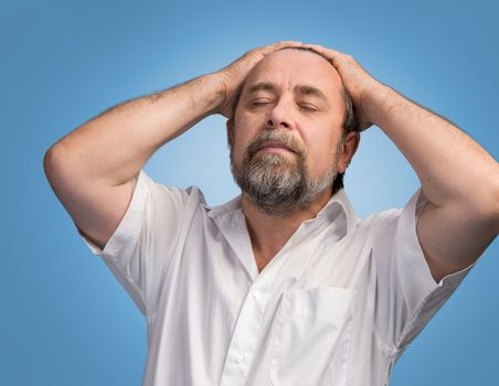 Portrait of an elderly man with hands held behind his head