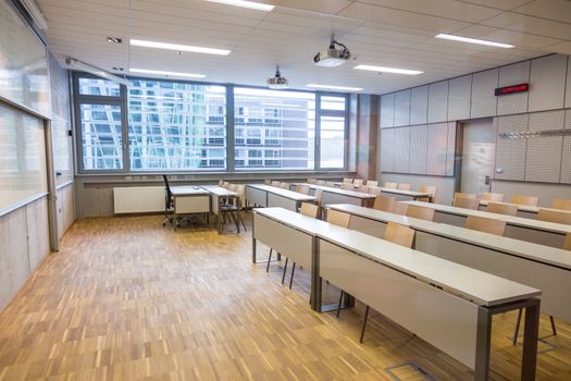 Empty, bright, modern college lecture hall with white board.