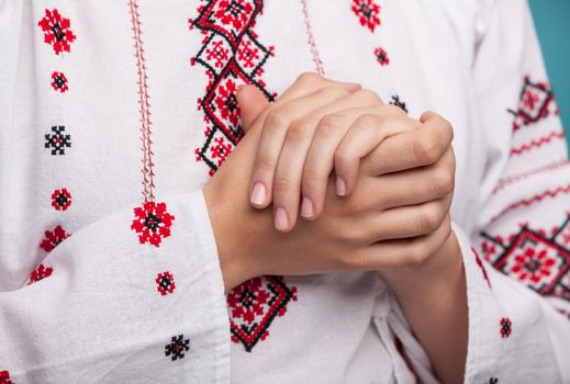 Hands of a young woman in the Ukrainian national clothes. Embroidered shirt