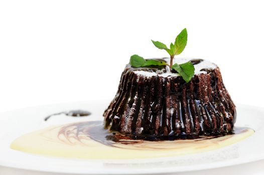Chocolate dessert fondant with peppermint leaves and icing on top