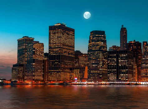 Manhattan at night with moon, lights and reflections. New York City skyline