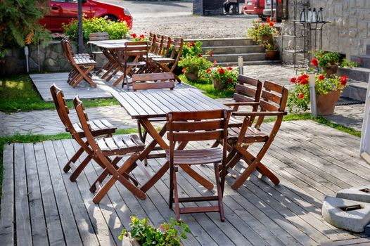 Empty outdoor cafe wooden table with chairs