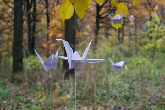 Paper crane in autumn Park. Origami tree at the Botanical garden, Russia