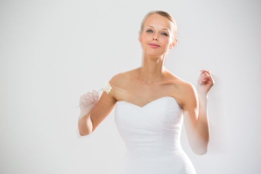 Gorgeous bride dancing, holding a rose (moiton blur technique used to convey the movement)