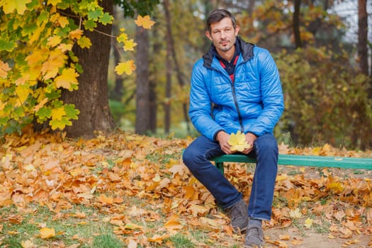 Men sitting on a bench in the autumn park