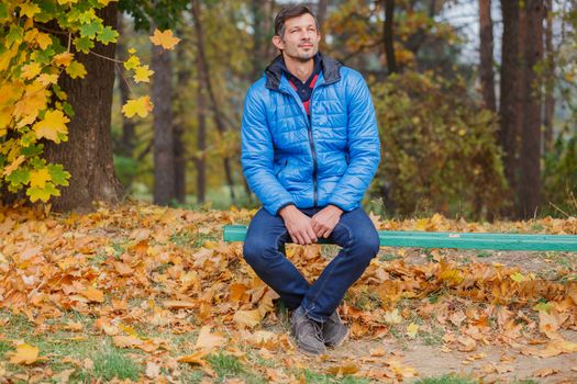 Men sitting on a bench in the autumn park