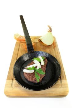 a piece of ostrich meat in an iron pan