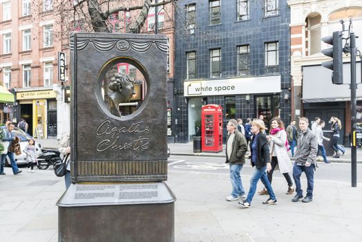 LONDON, UK - OCTOBER 26: Agatha Christie book shaped memorial with busy street in the background. The bronze memorial was unveiled on the 18 November 2012. October 26, 2014 in London.