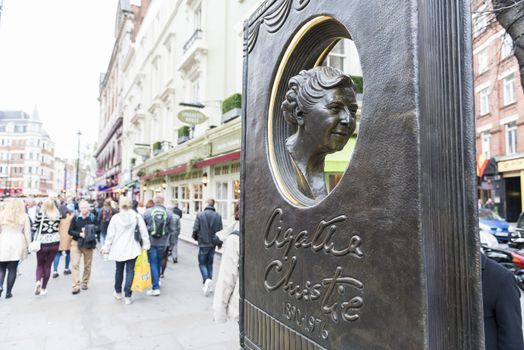 LONDON, UK - OCTOBER 26: Agatha Christie book shaped memorial with busy street in the background. The bronze memorial was unveiled on the 18 November 2012. October 26, 2014 in London.