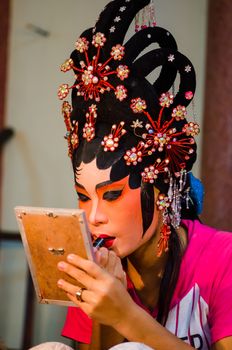BANGKOK - OCTOBER 22: Unidentified Chinese opera actress applies makeup backstage at Theaters of Thailand's ethnic Chinese in Chinatown on October 27, 2014 in Bangkok, Thailand.