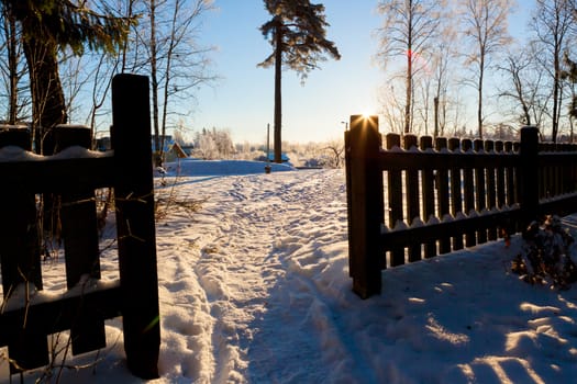 Sunshine wooden fence and footpath at winter