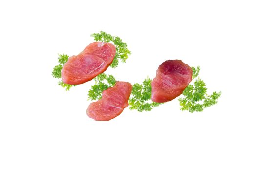 Three raw schnitzel with parsley against a white Hintergrung