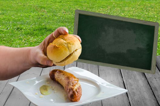 A bratwurst with bun on a white plate with mustard
