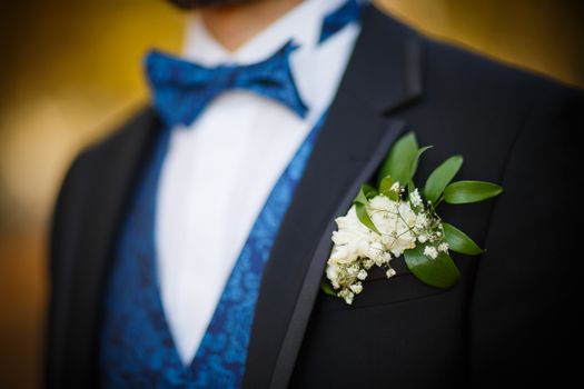 Bridegroom preparing for the wedding, boutonniere in Focus