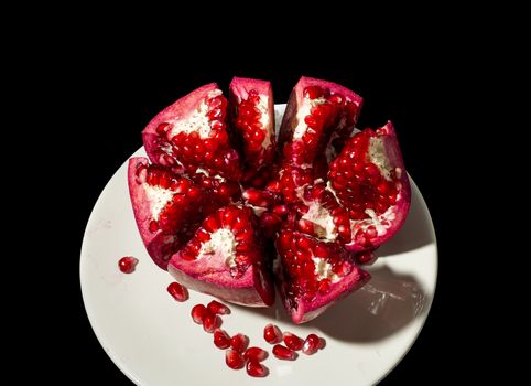 Ripe pomegranate fruit on black background cutout 