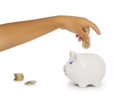 hand putting coin into a piggy bank isolated on white