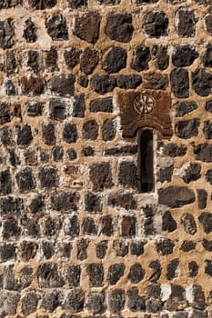 fragment of a stone wall of a fortress with a small window