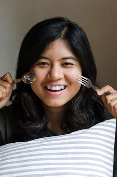Funny girl with spoon and fork, prepare to eat