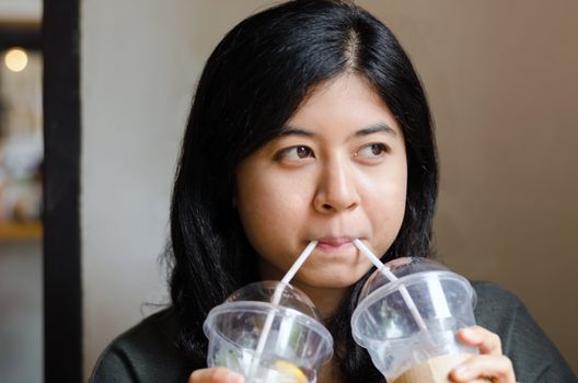 Funny woman drinking a two cups of coffee