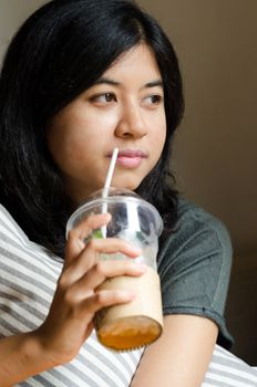 Relaxed woman drinking coffee at cafeteria