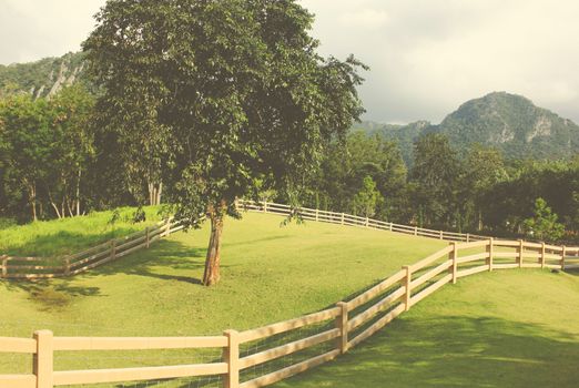 Fence and view of farmland in countryside with retro filter effect