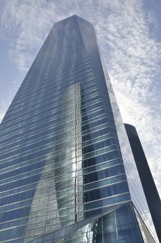 Reflection of the SpaceTower into the Crystal Tower in the Four Towers Business Area, Madrid, Spain. The Crystal tower was designed by Pelli and the Space tower by  Henry N. Cobb.