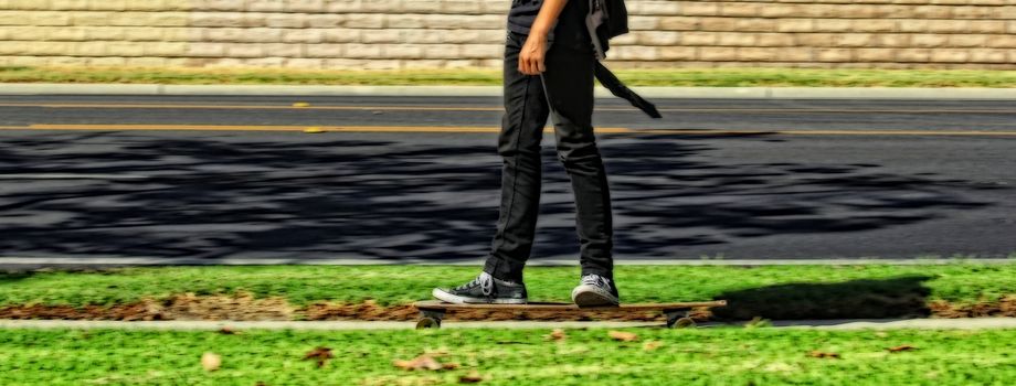 Teen skateboarding on the footpath.