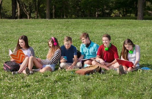 Group of teens using technology for studying