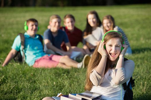 Happy female student with headphones singing outdoors