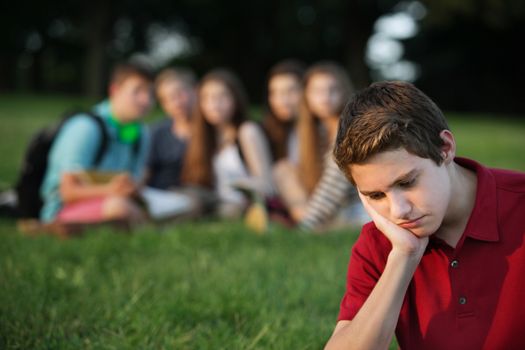 Sulking male caucasian teen with face in hands