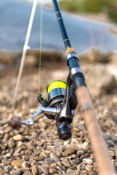 Modern clean fishing rod outdoors on the ground