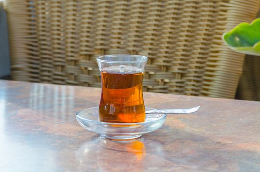 Turkish tea in glass cup and spoon on a table.