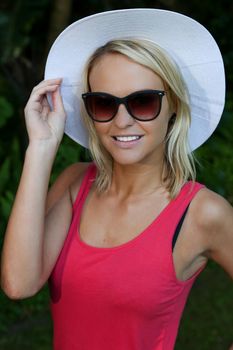 Lovely young blond lady posing is a wide brimmed hat