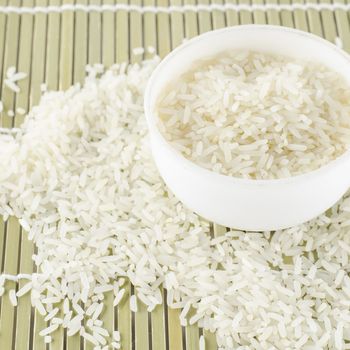 uncooked rice in mini bowl on wooden pad