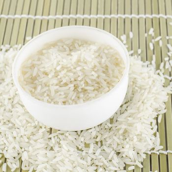 uncooked rice in mini bowl on wooden pad