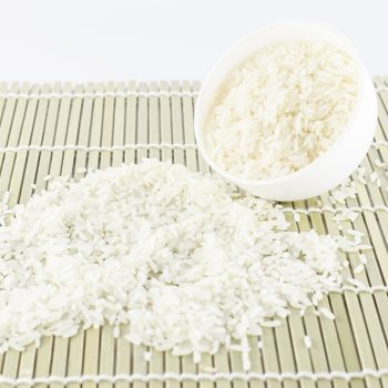 uncooked rice in mini bowl on wooden pad